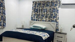 Camera da letto con un letto, comodini, una lampada, un cuscino e un condizionatore d'aria.