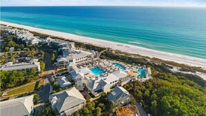 Un complexe hôtelier comprenant plusieurs bâtiments, une grande piscine et offrant une vue sur la plage.