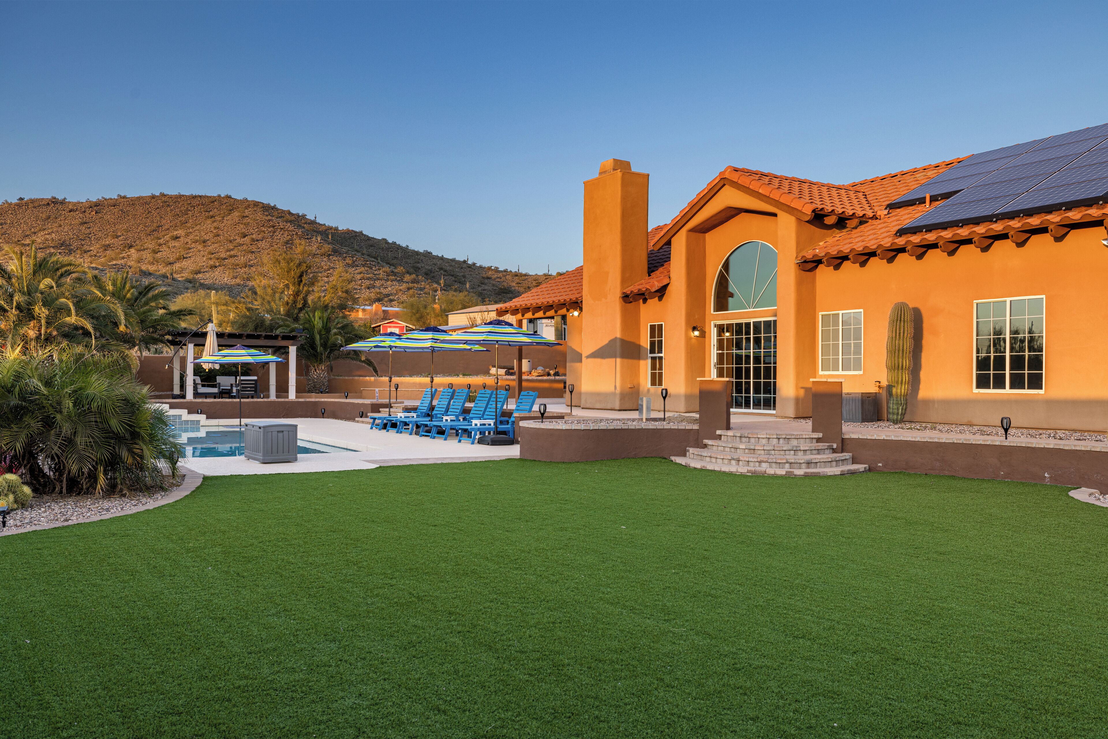 A building with a large patio area, outdoor seating, and a pool.