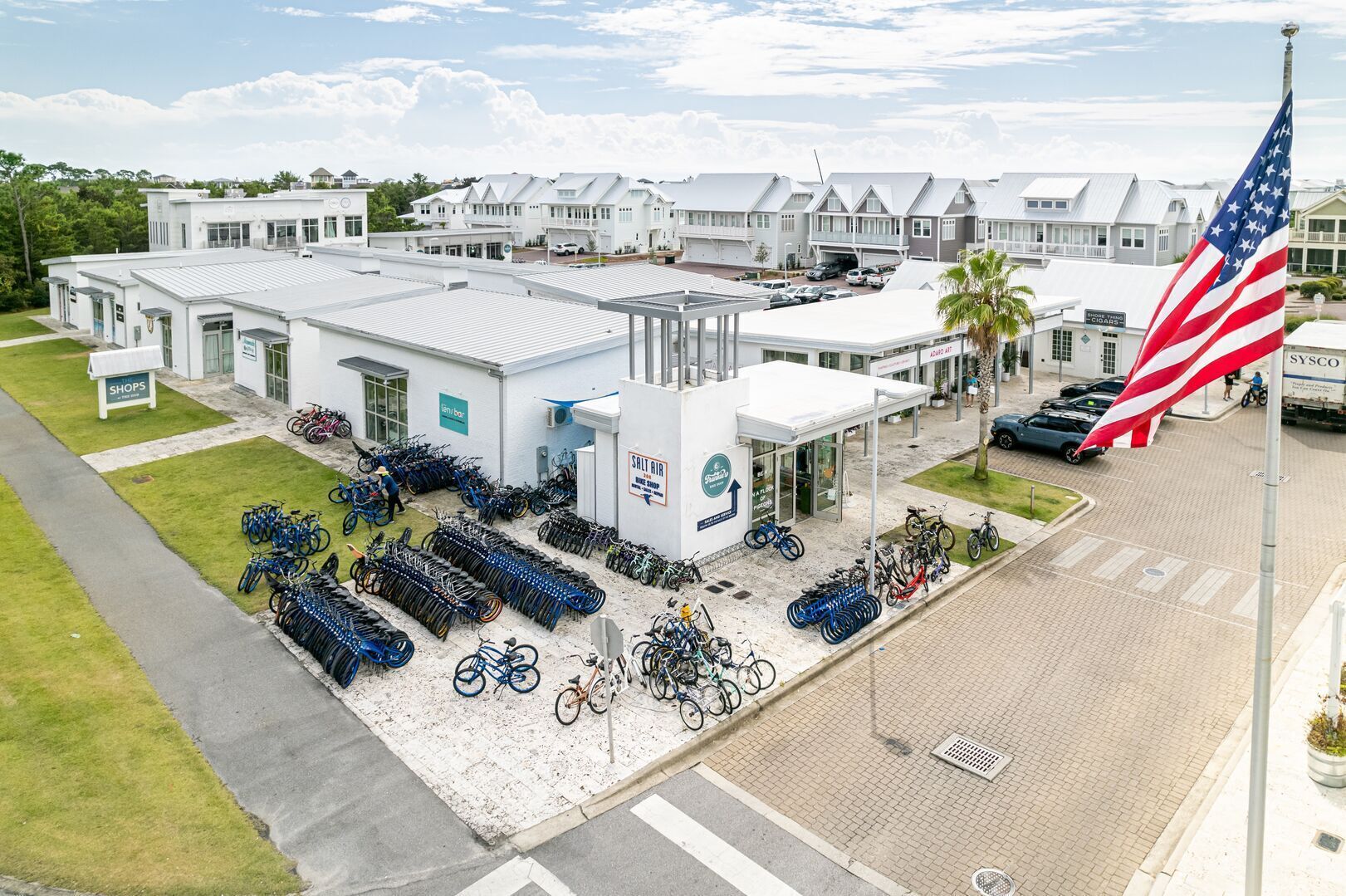 En byggnad med en vit fasad, en flagga och en plats för cykelparkering.