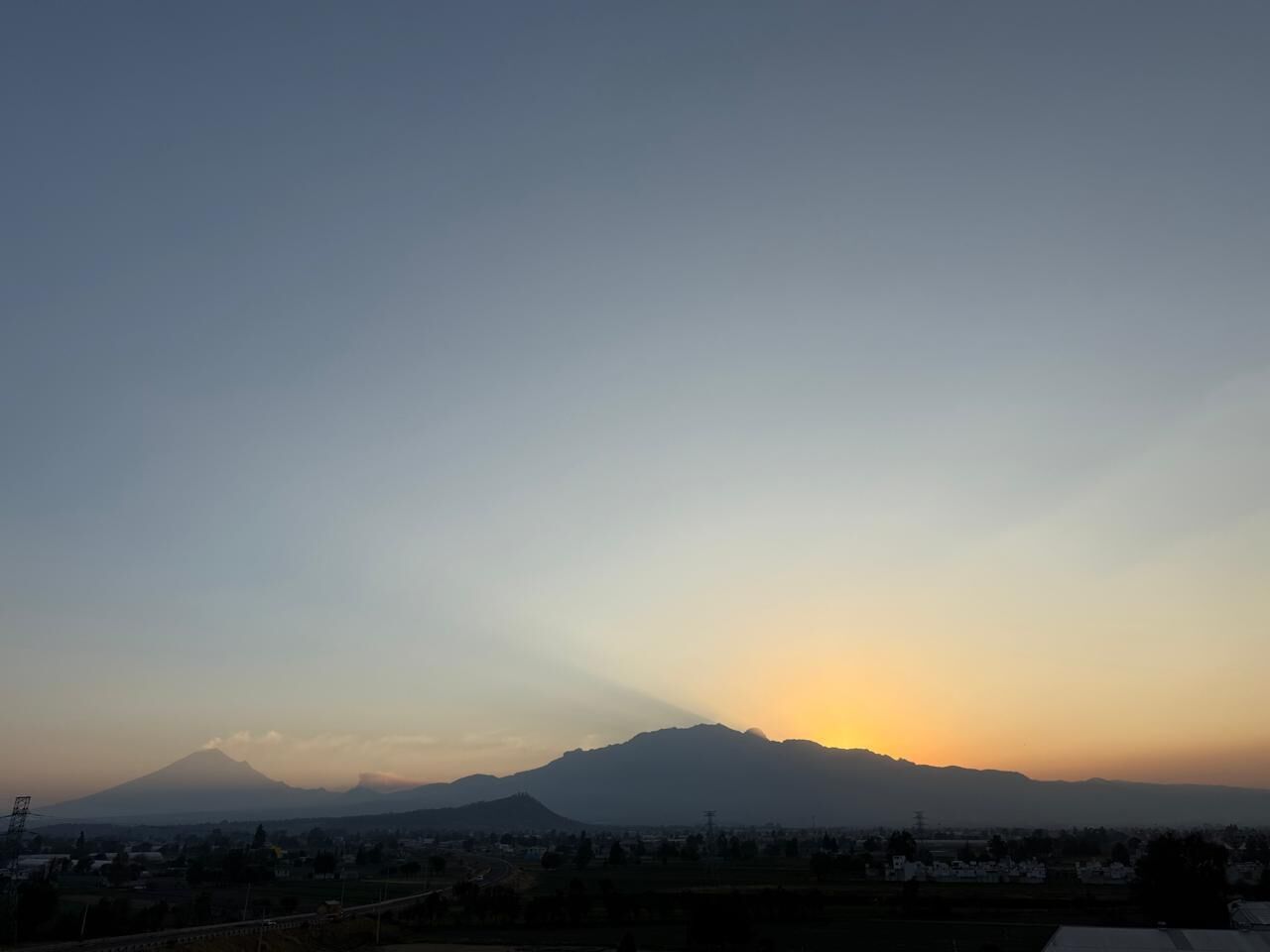 Silueta de una montaña contra un cielo despejado, probablemente indicando el amanecer o el atardecer.