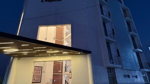 Un hôtel appelé « Los Angeles Hotel Restaurante & Negocios », doté d’une façade moderne et d’une enseigne lumineuse.