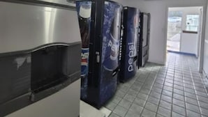 A hallway with vending machines and a refrigerator. - Budget Inn (Durham)