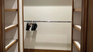 A walk-in closet with wooden shelving and a metal rod for hanging clothes. - Mountain Side luxury Condo (Ketchum)