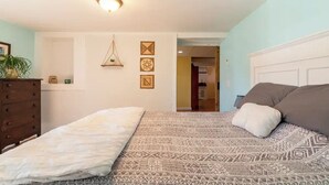 Quarto com cama, penteadeira e luminária pendente.