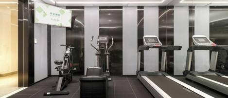 A modern gym with exercise equipment including treadmills, an elliptical, and weight machines.