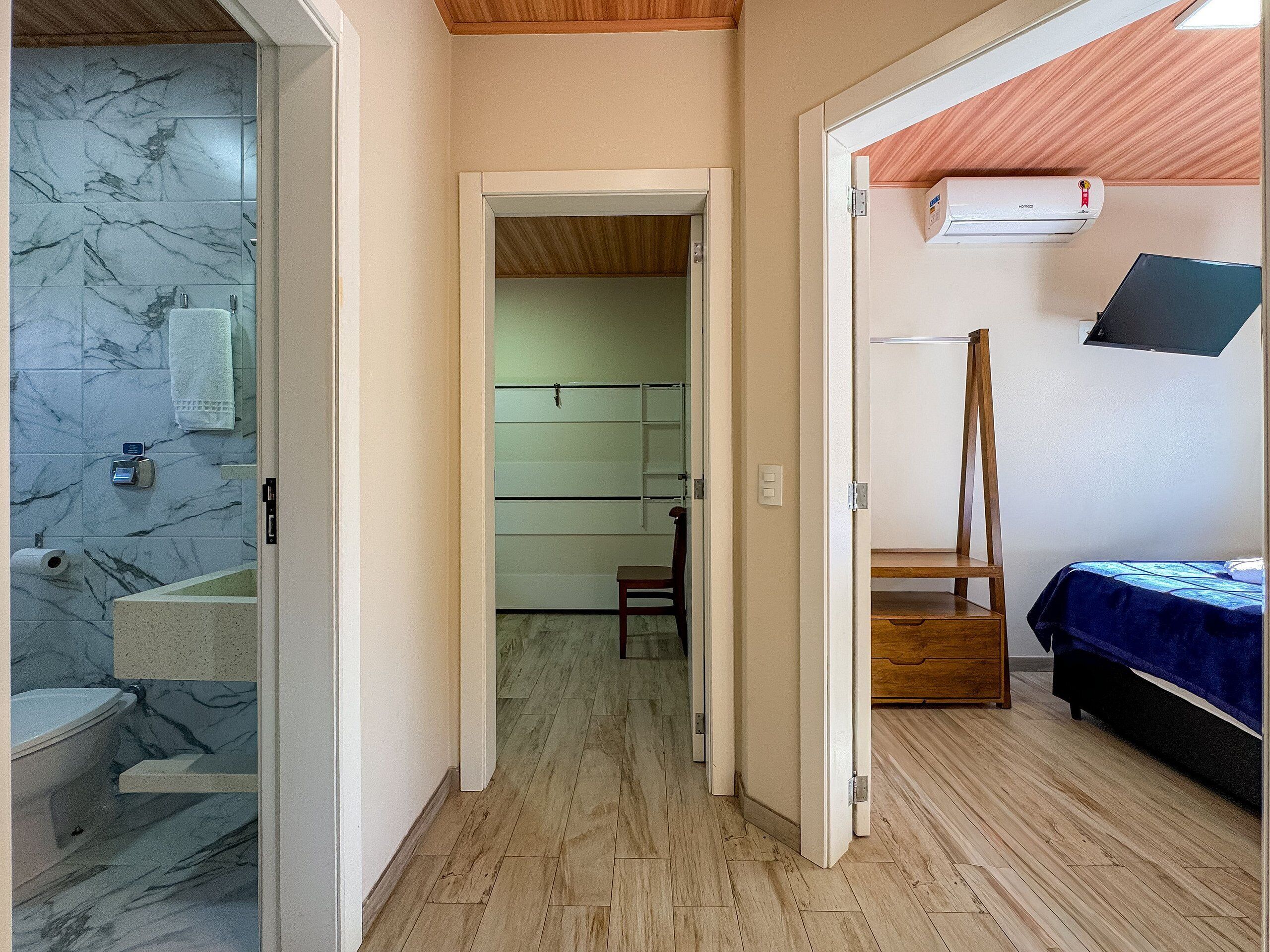 Un baño con azulejos de mármol, un inodoro y un perchero para toallas.