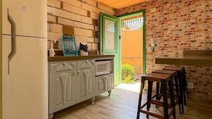 A kitchen with a refrigerator, cabinets, and a dining area with chairs. - Bella Serra Gramado Residence (Gramado)