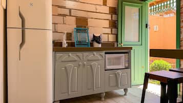 A compact kitchen with a refrigerator, microwave, and cabinets.