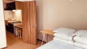 A bedroom with a bed, pillows, a desk, and a chair. - SkyHotel: 4-minute walk from Ryogoku Station; direct access to Ueno, Roppongi, and Shinjuku (墨田区亀沢2丁目)