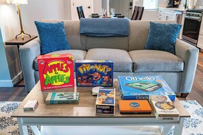 Een woonkamer met een bank, een salontafel en verschillende gezelschapsspellen.