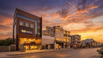 A multi-story hotel with a modern facade, a prominent sign, and a clear sky.