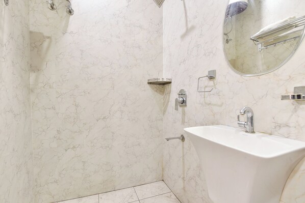 A bathroom with a shower, a sink, and a mirror. - Fabhotel Golden Sapphire (Jaipur)