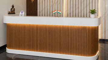 Un mostrador de recepción con detalles de madera e iluminación integrada.