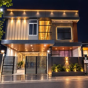 A modern two-story building with a flat roof, large windows, and a covered entrance area. - FabHotel The Sarnath Residency (Varanasi)