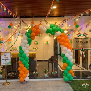 Entrada de hotel decorada con globos e insignias, indicando una celebración.