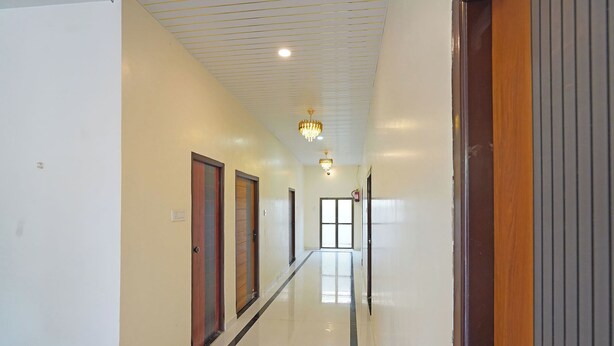 A hallway with doors, a chandelier, and a fire alarm. - Via The Sarnath Residency (Varanasi)