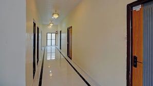 A hallway with a chandelier, doors, and a fire extinguisher. - Via The Sarnath Residency (Varanasi)