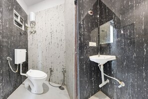 A bathroom with a toilet, a sink, a shower, and a mirror. - Fabhotel Welcome Inn Besa (Nagpur)