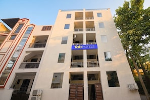 A multi-story building with a sign for 'fab hotels' indicating a hotel presence. - FabHotel Royal (Gurugram)