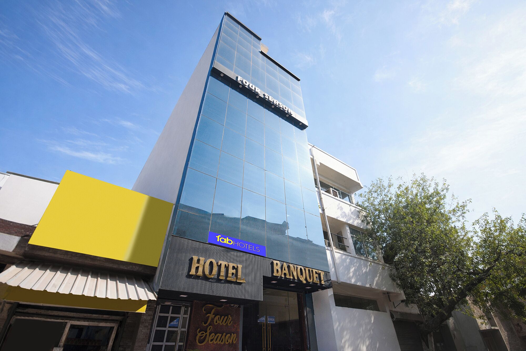 A hotel with a modern glass facade, a visible 'HOTEL BANQUET' sign, and a 'FOUR SEASON' sign on the upper part.