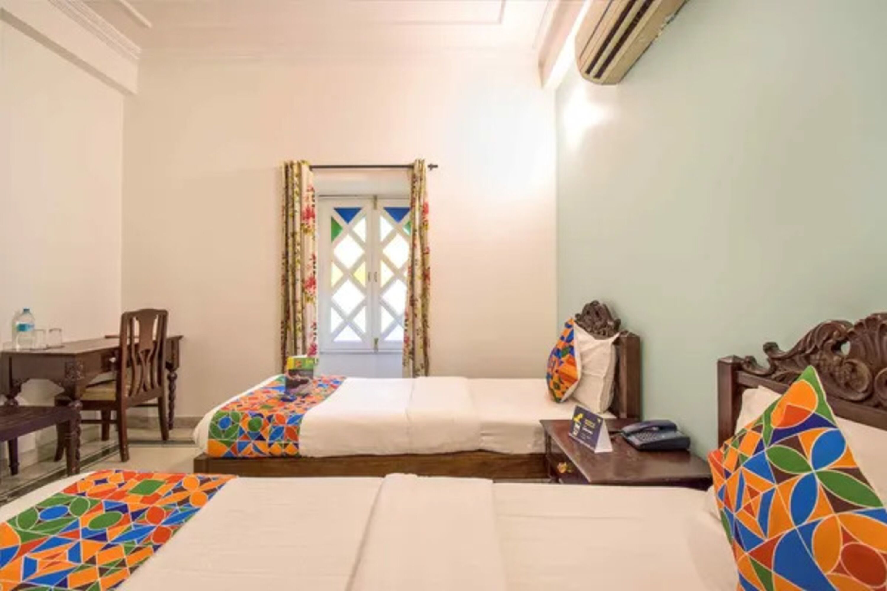 Habitación de hotel con dos camas, un escritorio y una silla.
