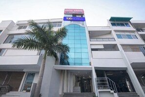 A multi-story hotel with a prominent sign for 'Hotel Grand' and 'Fab Hotels.' - Via Grand (New Delhi)