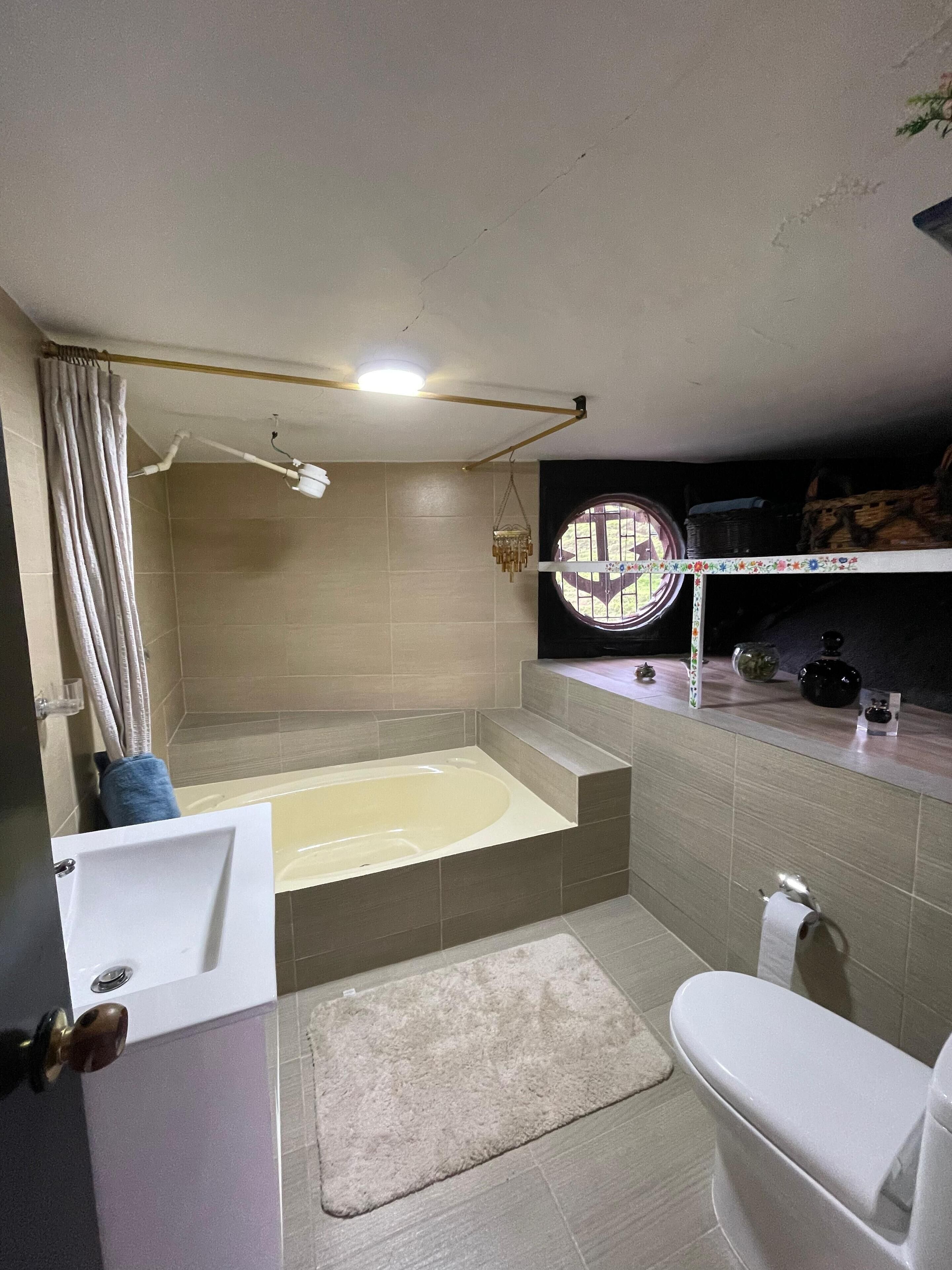 Un ba ño con bañera, inodoro y lavamanos.