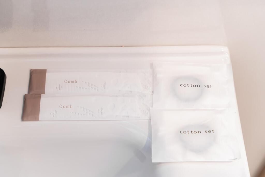 A white surface with two combs and two cotton sets.