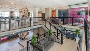 Um espaço amplo e interno com escada, assentos e vista para o exterior.