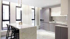 Uma cozinha moderna com uma ilha grande, eletrodomésticos embutidos e janelas amplas.