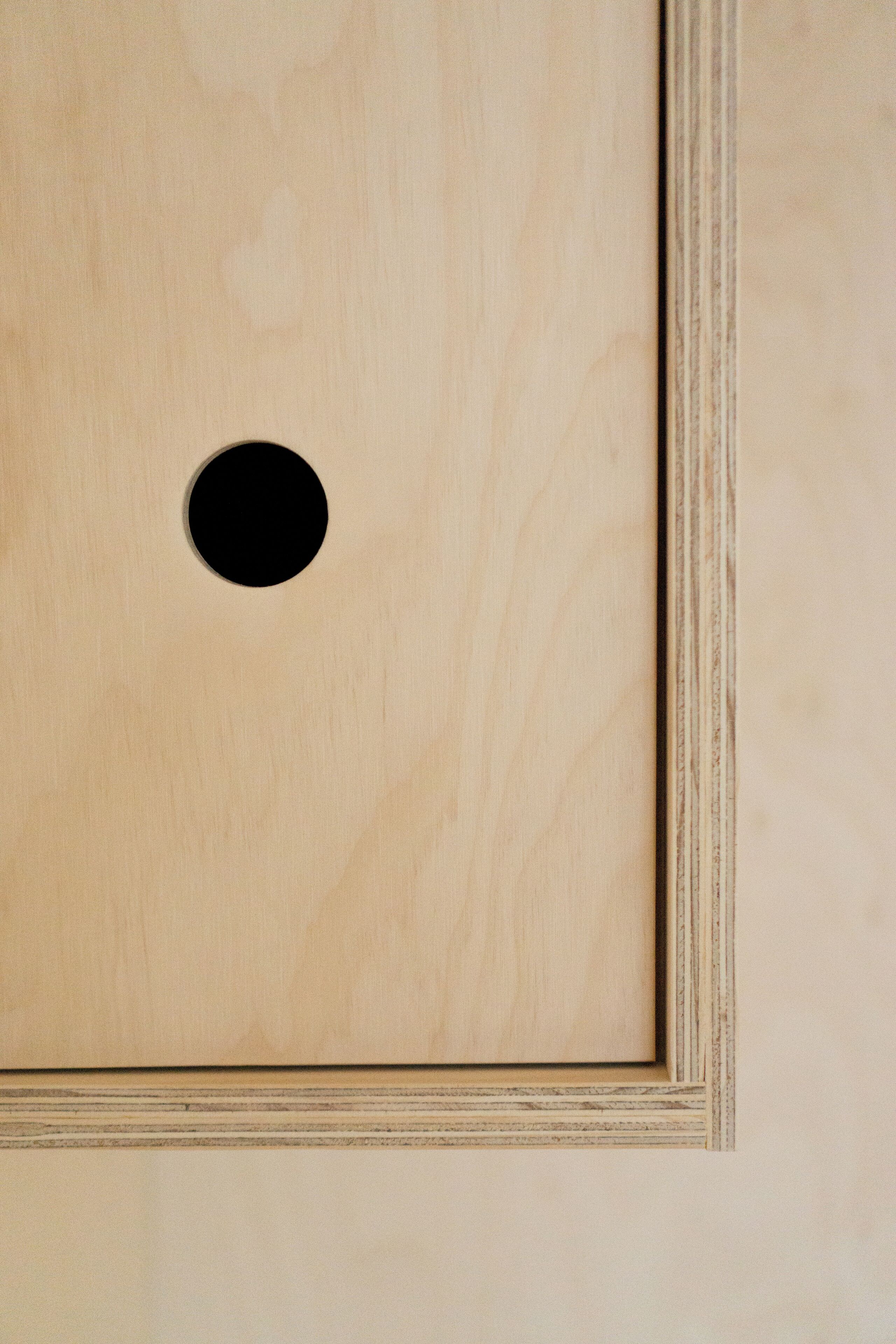 A wooden panel with a circular cutout.