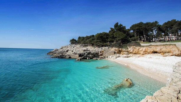 A coastal beach with clear turquoise waters, rocky cliffs, and a sandy shore. - Holiday apartment in the city centre (Pula)