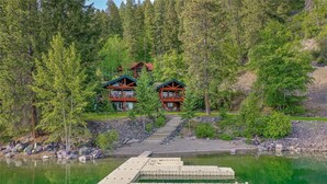 Eine Lodge mit zwei Hauptgebäuden, einem Steg und umgebenem Wald.