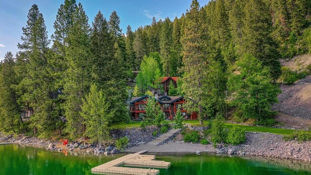 Eine Lodge mit einem Steg, der in einen See führt, umgeben von dichtem Wald.
