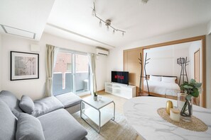 Ett modernt vardagsrum med en soffa, ett soffbord och en tv.