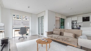 A modern living room with a sofa, a coffee table, and a desk with a chair. - Blueground | Whitechapel, fitness center, nr Tower of London (London)