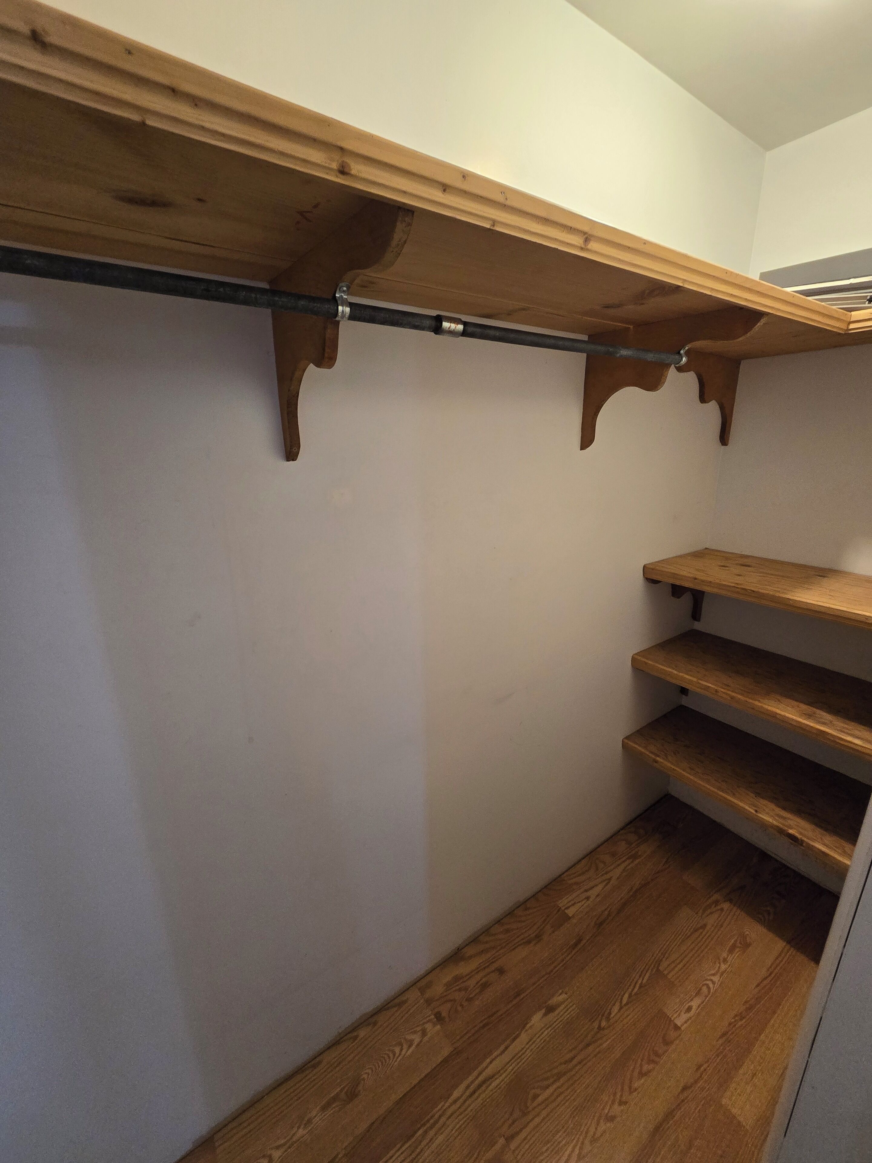 Un placard en bois avec une étagère en métal et trois étagères en bois.