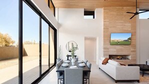 A modern dining area with a large table, chairs, and a television mounted on the wall. - Nyx - Near Troon North Golf & Scottsdale Quarter (Scottsdale)