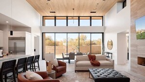 A modern interior with a kitchen, dining area, and seating space with large windows. - Nyx - Near Troon North Golf & Scottsdale Quarter (Scottsdale)