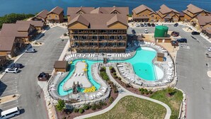 Een resort met een groot zwembad, meerdere gastenkamers en een parkeerplaats.