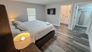 A bedroom with a bed, bedside lamp, and a window with blinds. - 5.0 Rated 3BR Retreat • Gated Patio • Near WEC (OCALA)