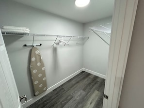 A small laundry room with a drying rack, a hanging towel, and a wooden floor. - 5.0 Rated 3BR Retreat • Gated Patio • Near WEC (OCALA)