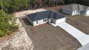 A single-story house with a dark roof, a front porch, and a garage. - 5.0 Rated 3BR Retreat • Gated Patio • Near WEC (OCALA)
