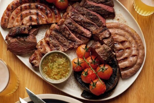 Un plato de carnes a la parrilla y verduras.
