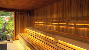 Una sauna con panche in legno e vista sul verde circostante.