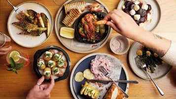 A dining table with various dishes, including seafood, bread, and salads.