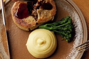 A plate with a food item, possibly a meat pie, a dollop of sauce, and a piece of broccoli. - Bishopstrow Hotel and Spa - Small Luxury Hotels of the World (Bishopstrow)