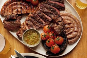 A plate of grilled meats and vegetables. - Bishopstrow Hotel and Spa - Small Luxury Hotels of the World (Bishopstrow)