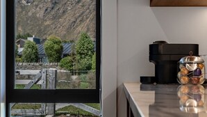 A kitchen with a view of a mountainous landscape through a window. - Jacks Point Ultimate Family Escape With Remarkable Views (Queenstown)